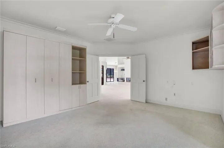 Ensuite bedroom featuring Murphy bed, ceiling fan and crown molding