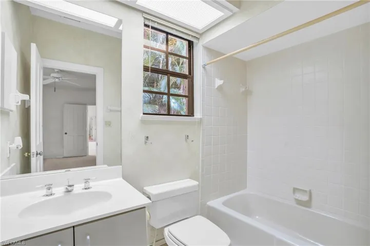 Full bathroom with ceiling fan, vanity, and large mirror