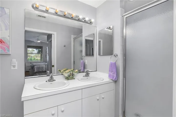 Full bathroom with a sink, a shower stall, and ensuite bathroom