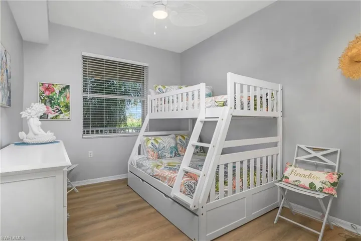 Bedroom with wood finished floors, a ceiling fan, and baseboards