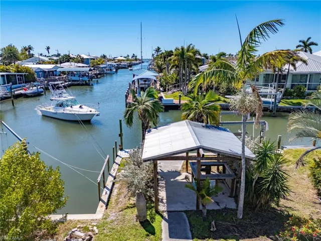 View looking south down the canal to the bay. Shared cut-in boat slip and covered bar with metal roof