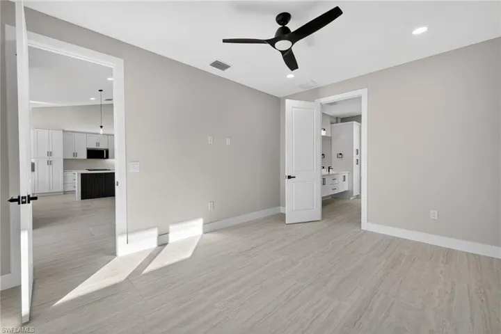 Unfurnished bedroom featuring a ceiling fan, recessed lighting, light wood-style flooring, and lofted ceiling