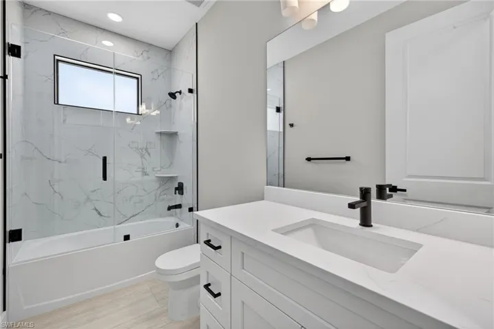 Full bath featuring vanity and bath / shower combo with glass door