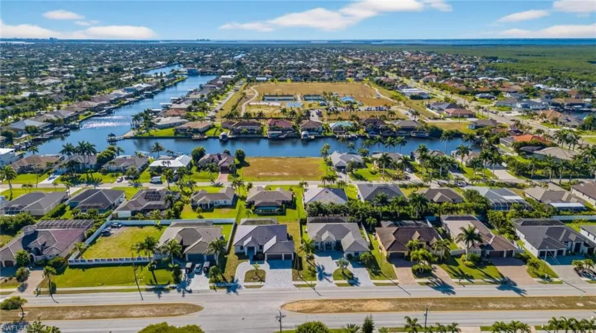 Aerial perspective of suburban area featuring a nearby body of water