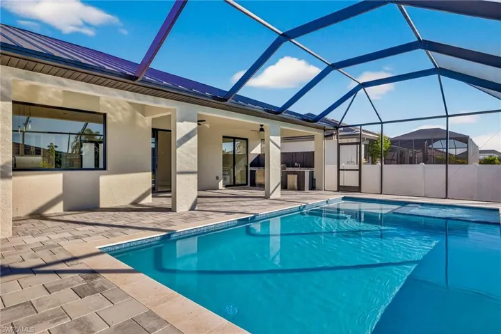 Outdoor pool featuring glass enclosure, a sunroom, and a patio area