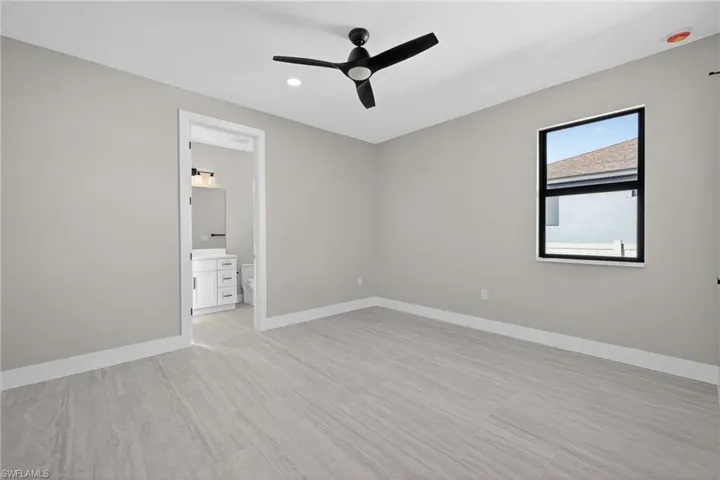 Unfurnished bedroom featuring ceiling fan, light wood finished floors, recessed lighting, and connected bathroom