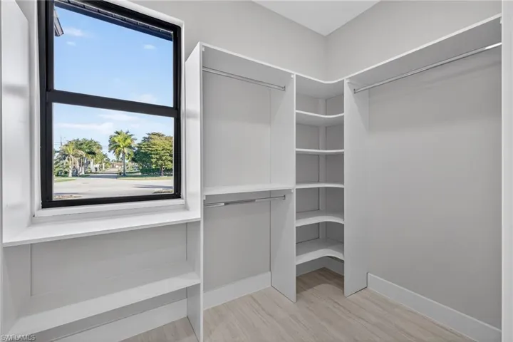 Walk in closet with light wood-style flooring