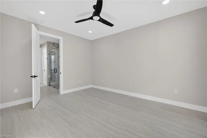 Unfurnished bedroom with ceiling fan, light wood finished floors, recessed lighting, and attic access