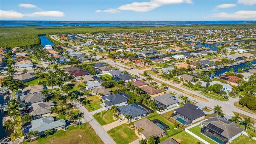 Aerial view of property and surrounding area with nearby suburban area and a large body of water
