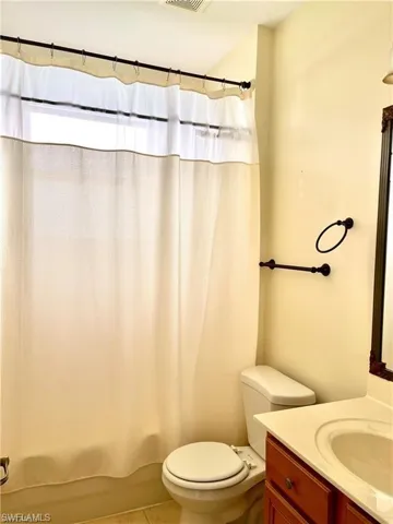 Bathroom with vanity, light tile patterned floors, and shower / bath combo with shower curtain
