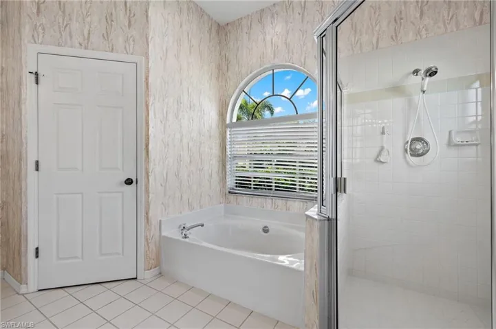 Bathroom with tile floors and shower with separate bathtub