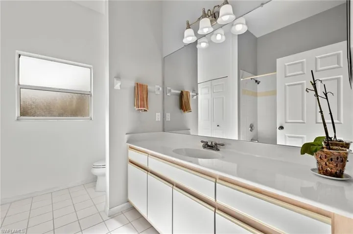 Bathroom featuring tile flooring, toilet, and large vanity