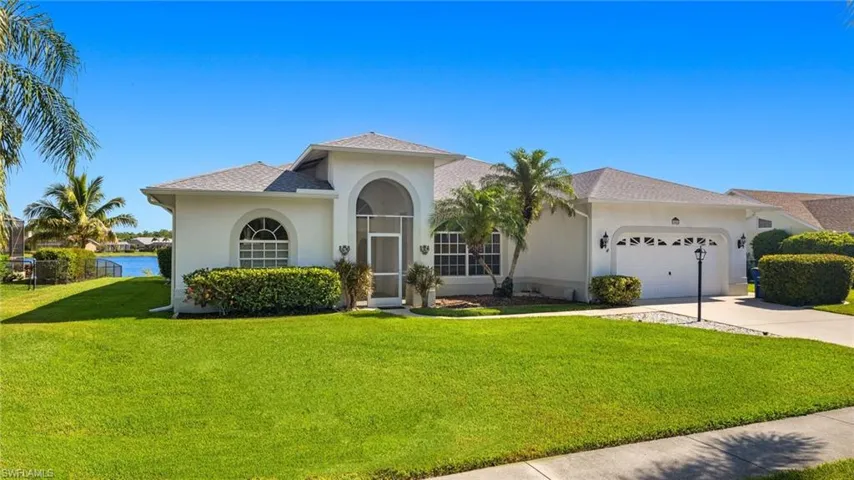 Mediterranean / spanish-style home with a garage and a front lawn