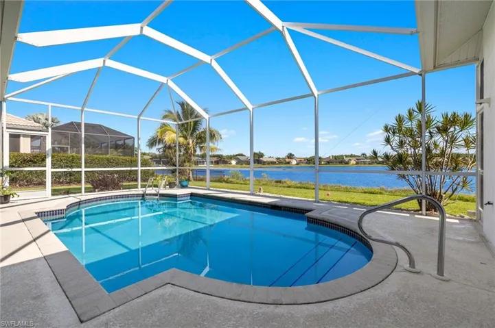 View of pool with glass enclosure and a patio