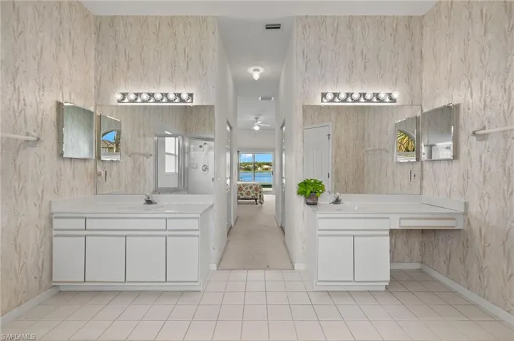 Bathroom featuring tile floors, ceiling fan, oversized vanity, and double sink