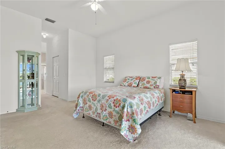 Carpeted bedroom featuring ceiling fan