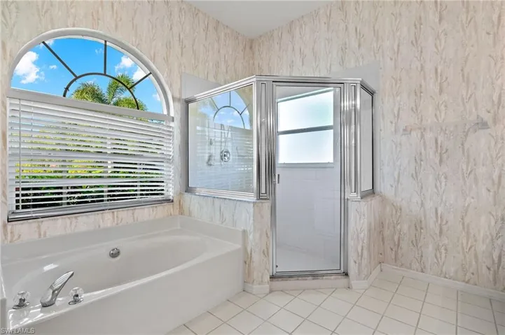 Bathroom featuring a wealth of natural light, tile flooring, and separate shower and tub