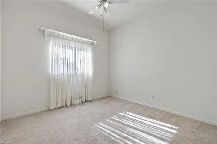 Carpeted empty room with ceiling fan