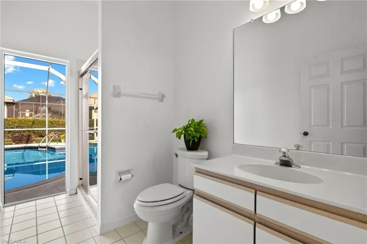 Bathroom with tile floors, an enclosed shower, vanity, and toilet
