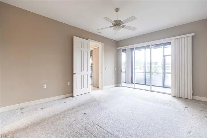 Spare room with light colored carpet, baseboards, and ceiling fan