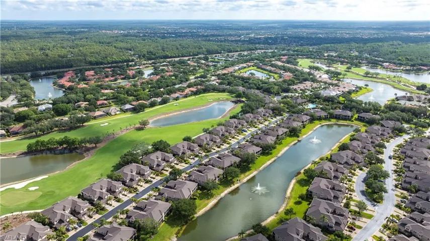 Aerial view of property and surrounding area with nearby suburban area, a golf club, and a large body of water