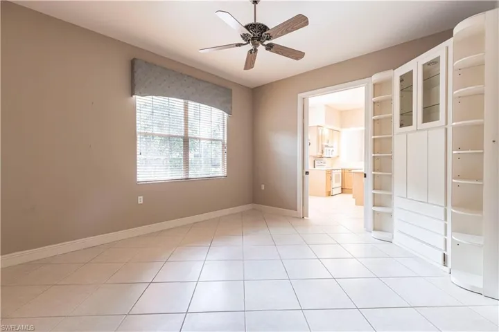 Spare room with a ceiling fan, light tile patterned floors, and baseboards