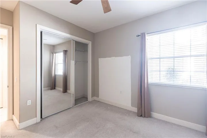 Unfurnished bedroom with carpet floors, a closet, a ceiling fan, and baseboards