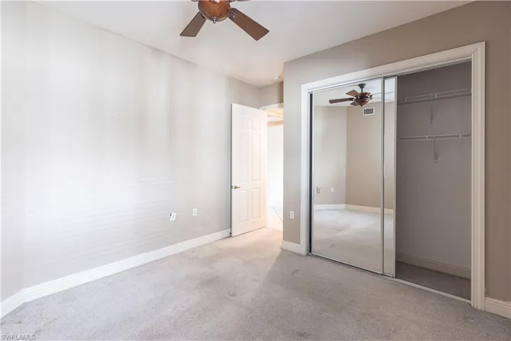 Unfurnished bedroom with a closet, carpet flooring, baseboards, and ceiling fan