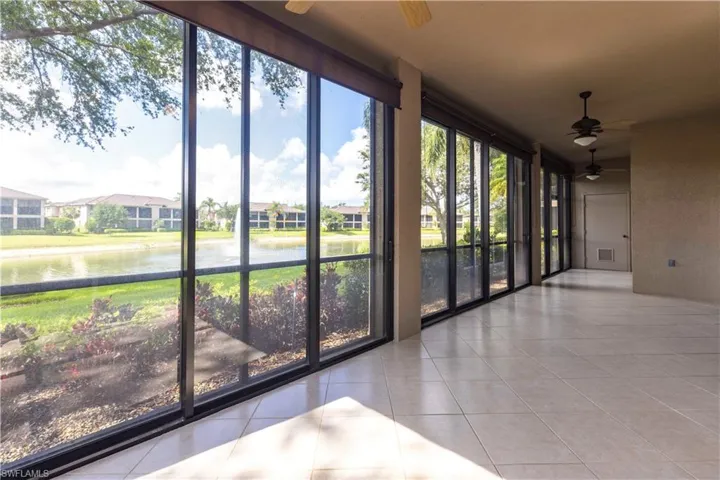 Unfurnished sunroom with a water view, tile patterned flooring, plenty of natural light, and expansive windows