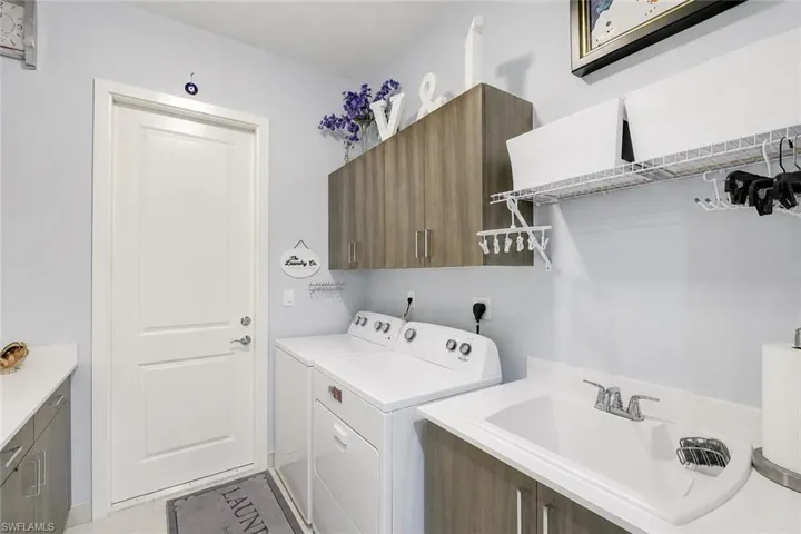 Laundry with full cabinetry & Sink