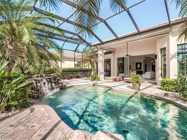View of swimming pool with a patio, pool water feature, glass enclosure, and ceiling fan