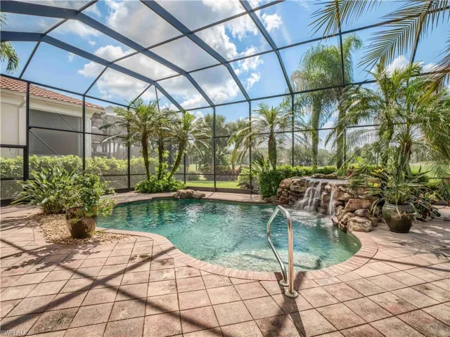 View of pool featuring a lanai, pool water feature, and a patio