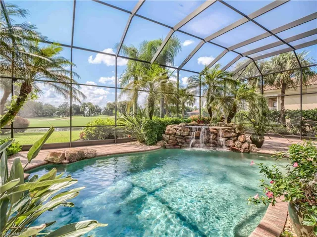 View of pool with pool water feature and a lanai