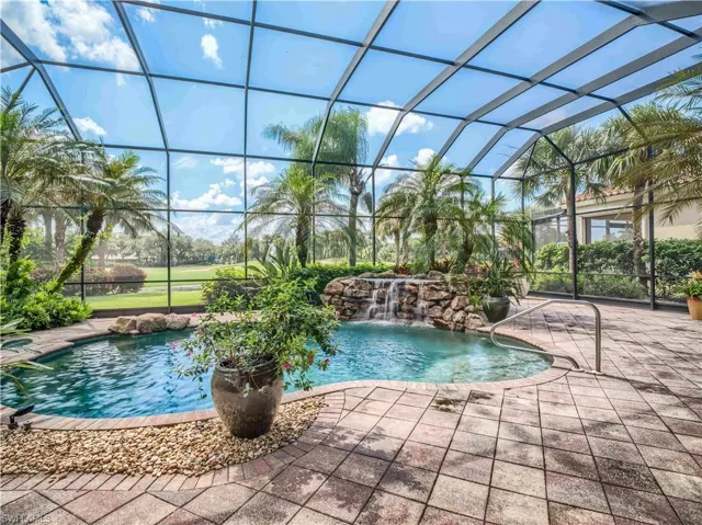 View of pool with a patio, a lanai, and pool water feature