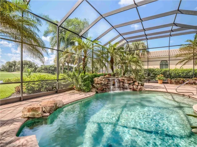 View of swimming pool with glass enclosure and pool water feature