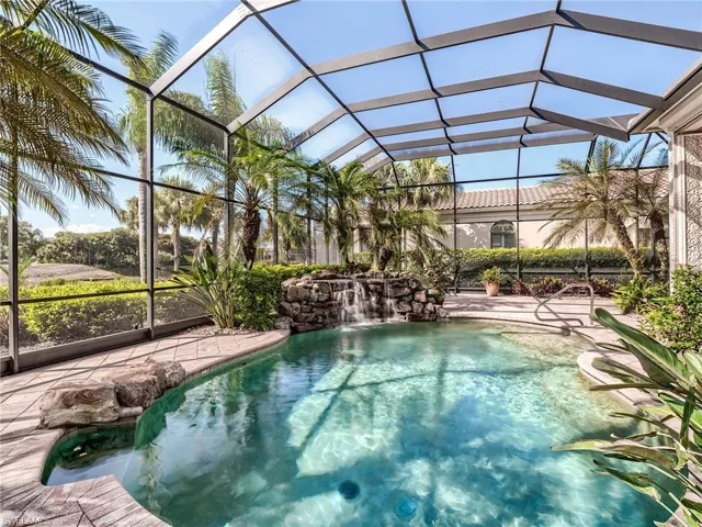 View of swimming pool with glass enclosure and pool water feature