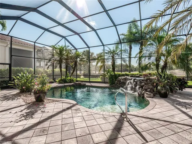 View of pool featuring a patio area, pool water feature, and glass enclosure