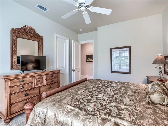 Carpeted bedroom featuring ceiling fan