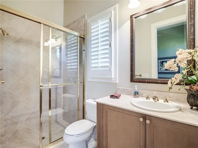 Bathroom featuring walk in shower, toilet, and large vanity