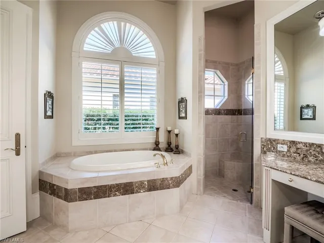 Bathroom with a wealth of natural light, independent shower and bath, and tile floors