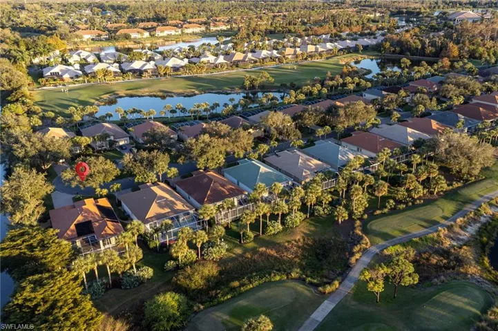 Aerial view of property and surrounding area with a golf course, nearby suburban area, and a nearby body of water
