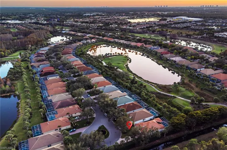 Aerial view at dusk of a water view, a residential view, and golf course view