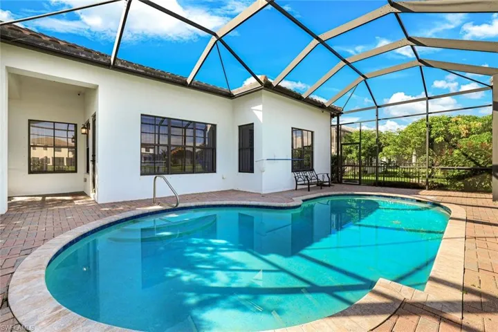Swimming pool with a sunroom, a patio, and glass enclosure
