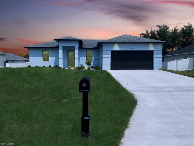 View of front of home featuring a garage and a lawn