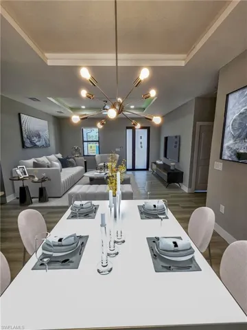 Dining area featuring dark hardwood / wood-style floors, an inviting chandelier, and a tray ceiling
