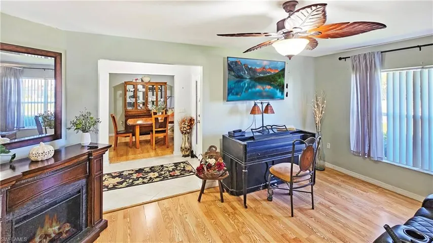 Office space with a fireplace, light hardwood / wood-style flooring, and ceiling fan