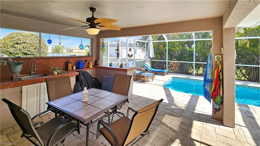 View of patio featuring ceiling fan, a lanai, and an outdoor wet bar