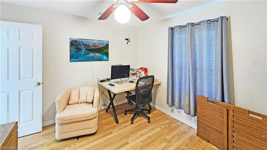 Office space with light hardwood / wood-style floors and ceiling fan