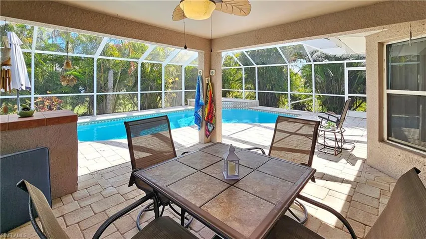 View of swimming pool featuring a lanai, a patio area, and ceiling fan