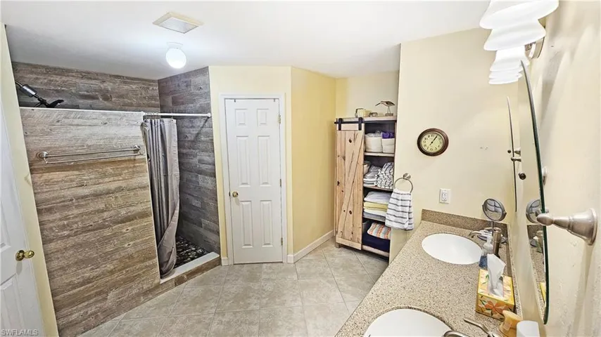 Bathroom with vanity, tile patterned floors, and a shower with shower curtain